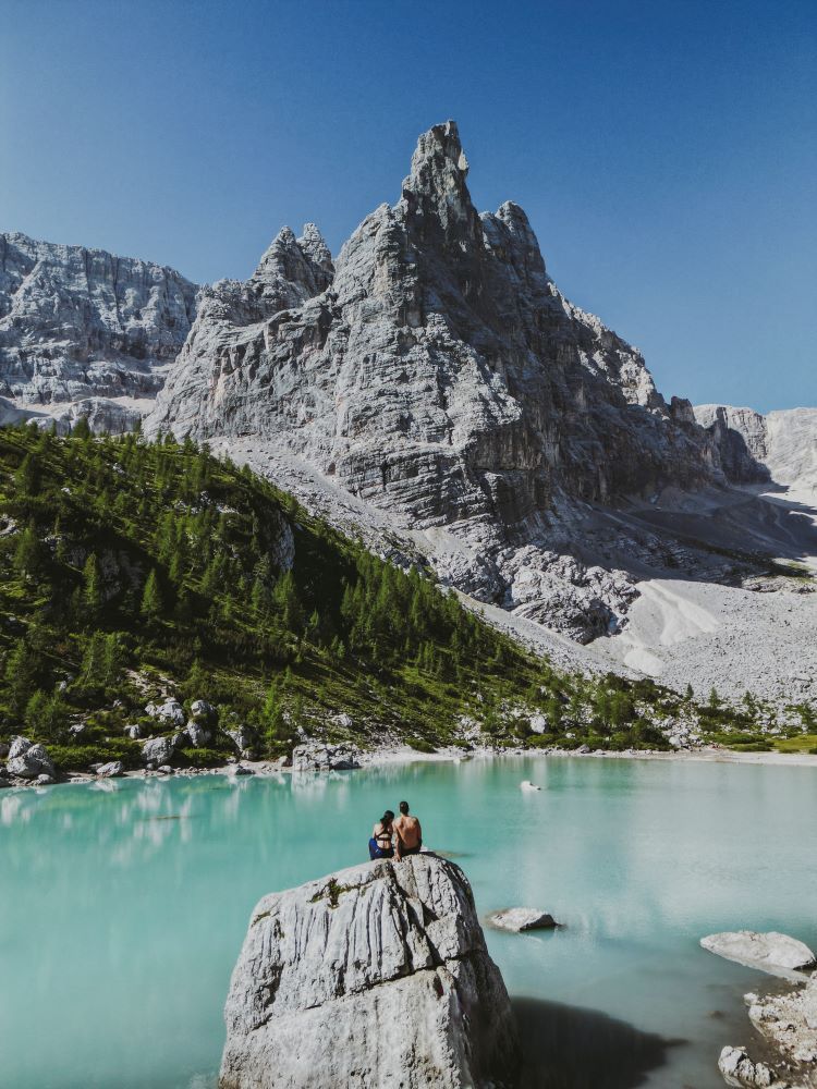 imagen lago con montaña y dos personas de lejos en lago sorapis